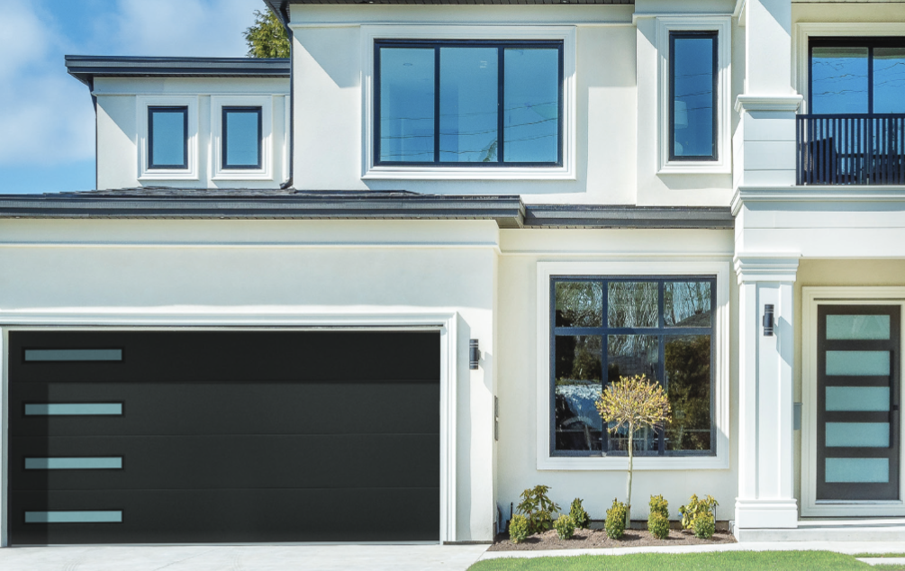 A white house with a black garage door and windows.