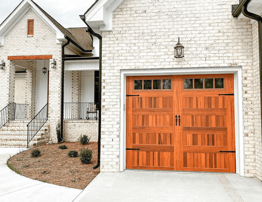A white brick house with a wooden garage door.
