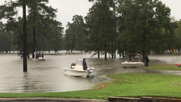 A group of boats are floating on top of a flooded lake.
