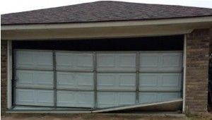 A brick house with a broken garage door.