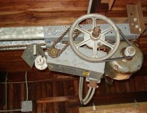 A garage door opener is hanging from the ceiling in a garage.