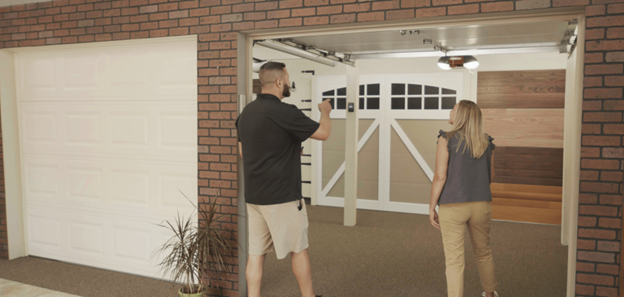 A Professional Staff showing details regarding the Garage Door to a client.