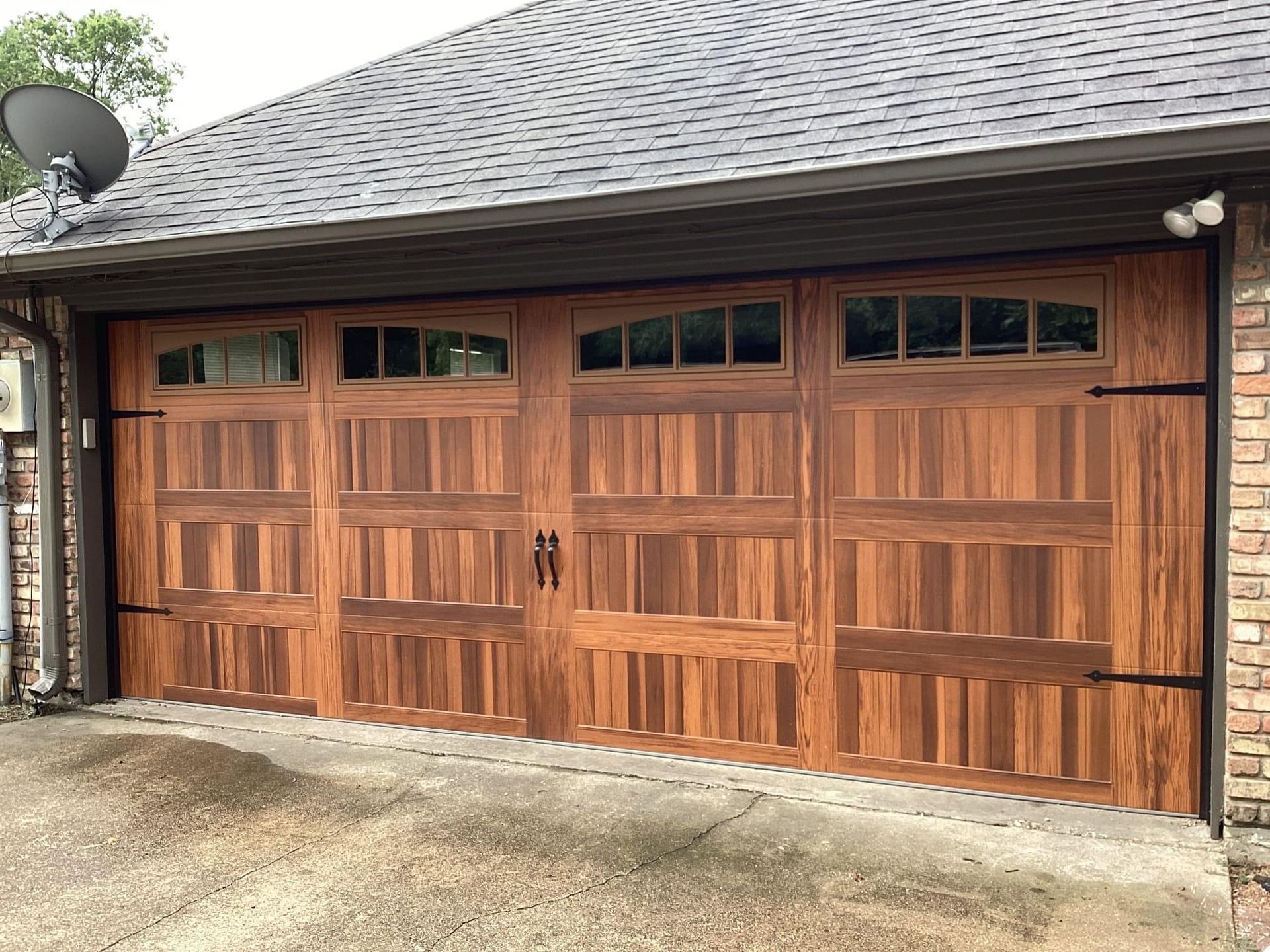 A large wooden garage door with a satellite dish on top of it.