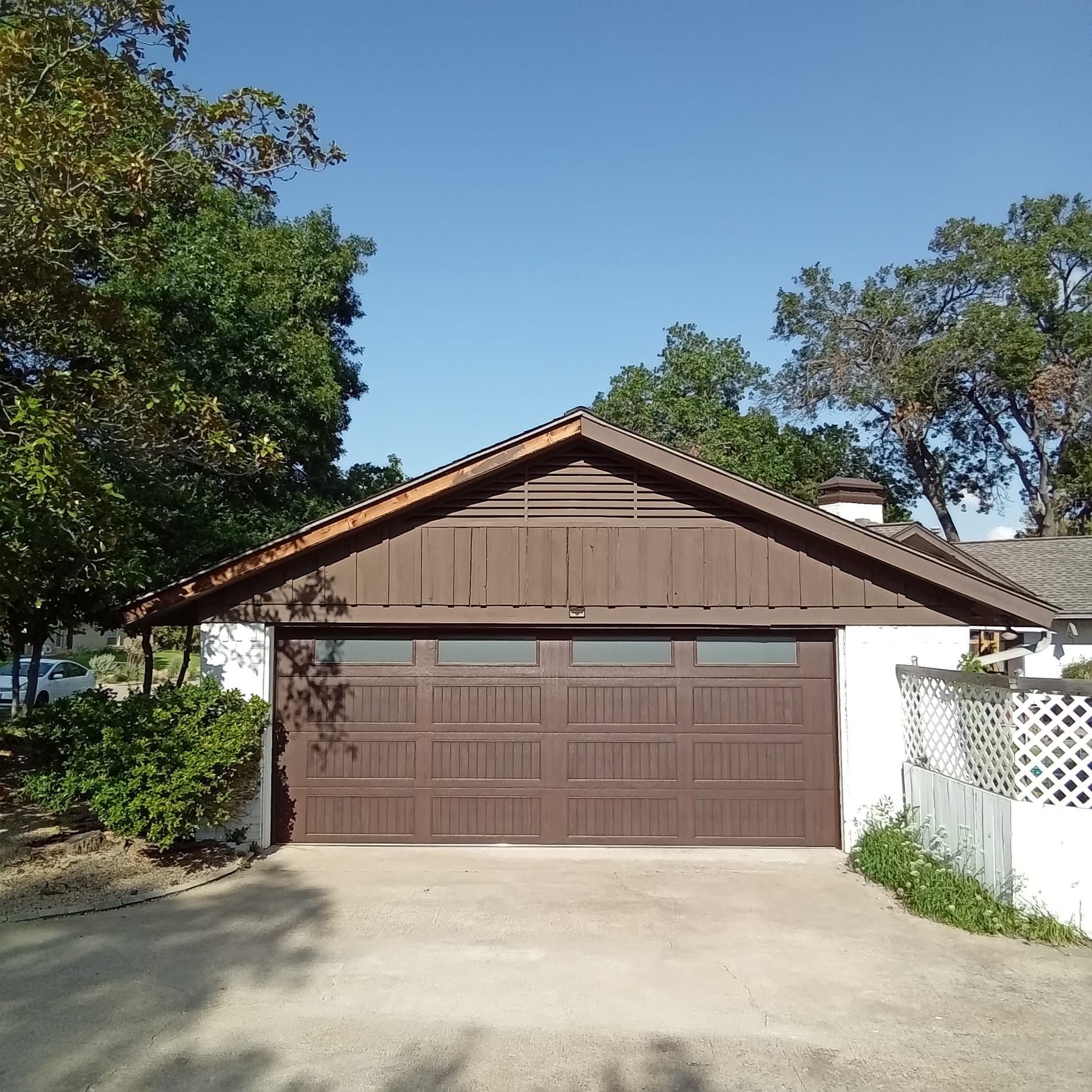 A garage with a brown door and a wooden roof