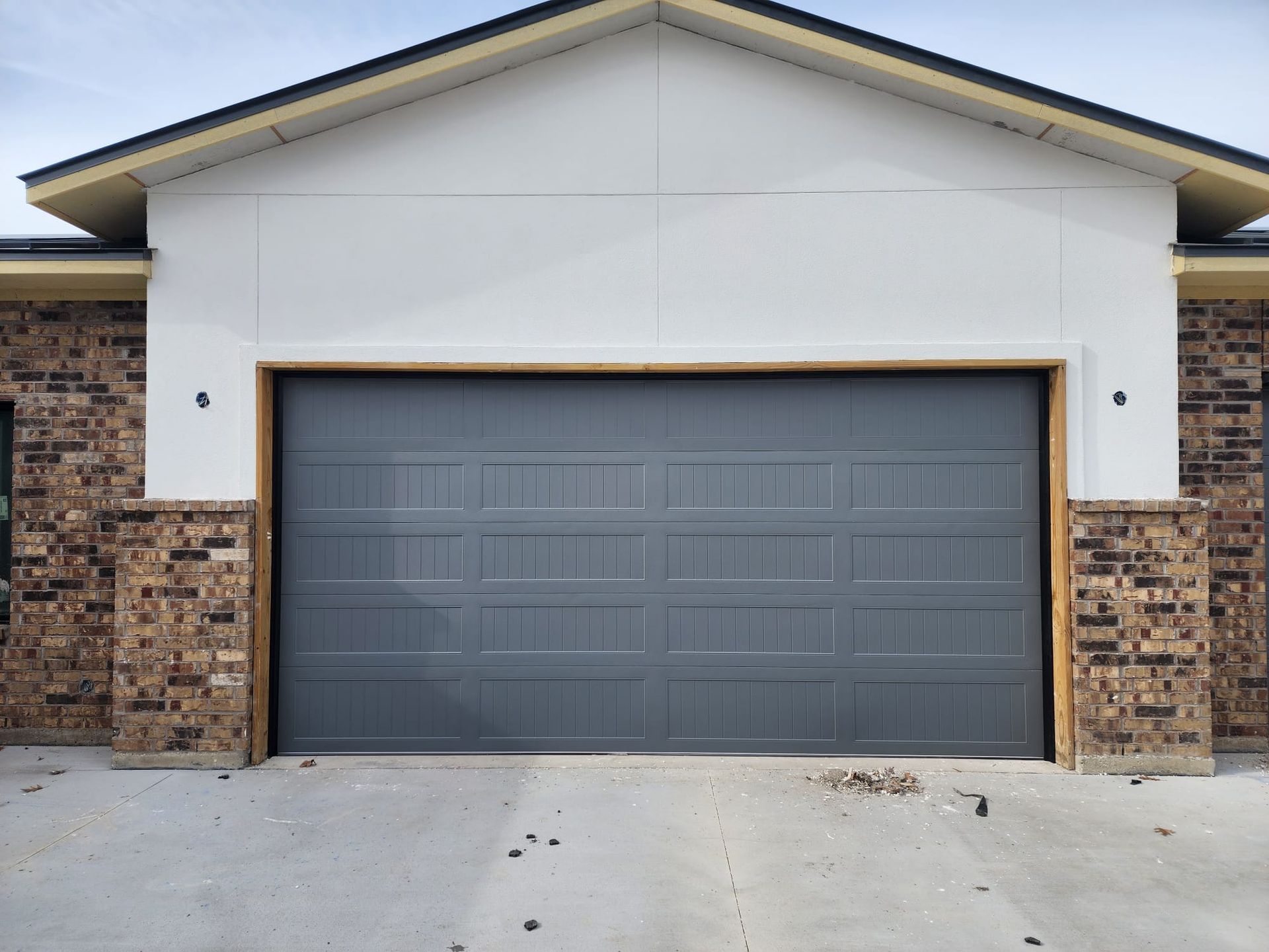 A brick house with a gray garage door