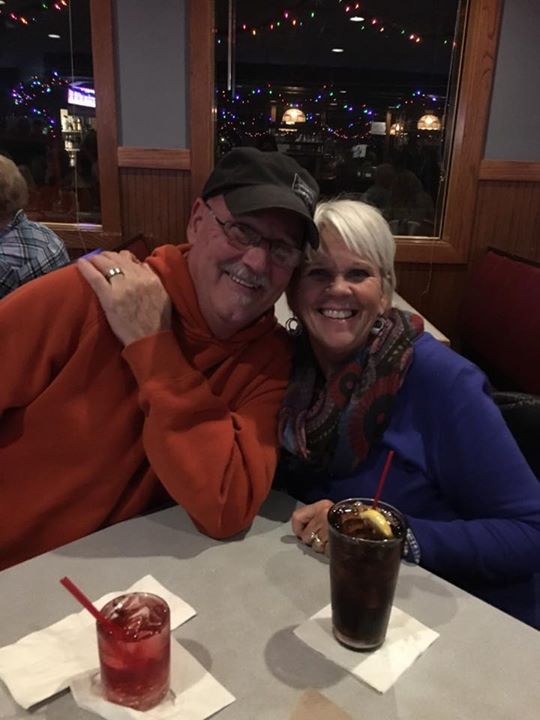 A man and a woman are sitting at a table with drinks