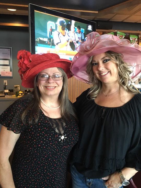 Two women wearing hats are posing for a picture