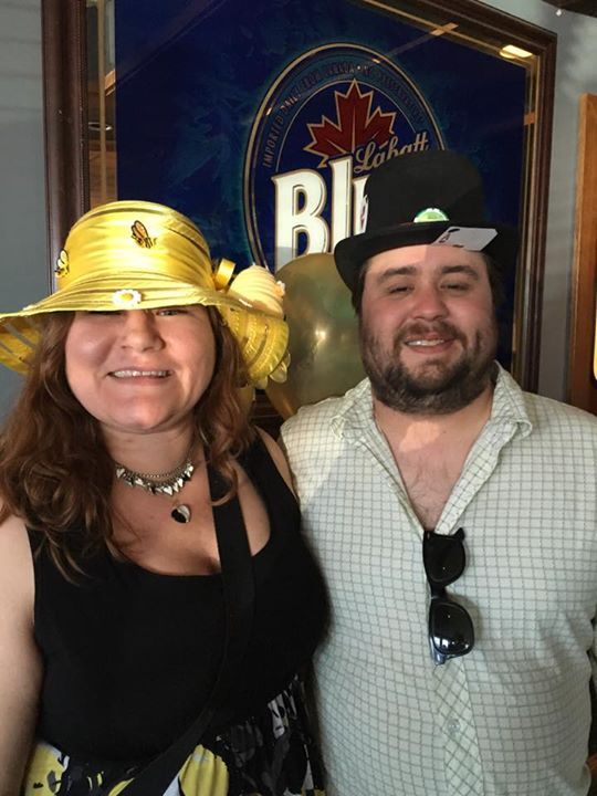 A man and a woman wearing hats are posing for a picture.