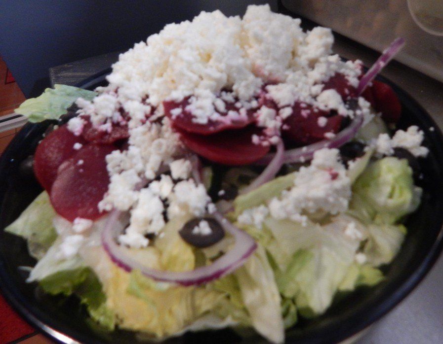A close up of a salad with a spoon in it