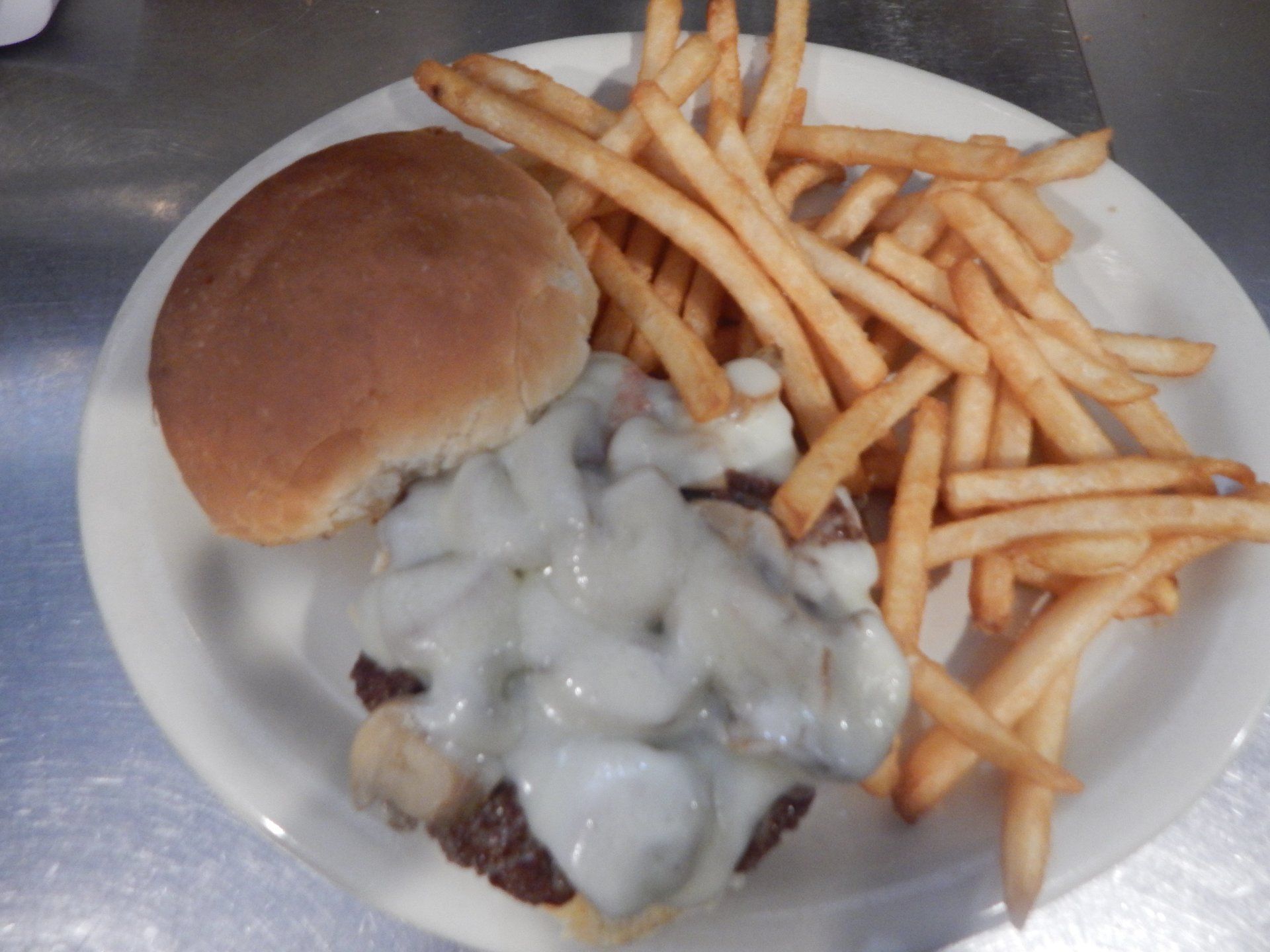 A white plate topped with a hamburger and french fries