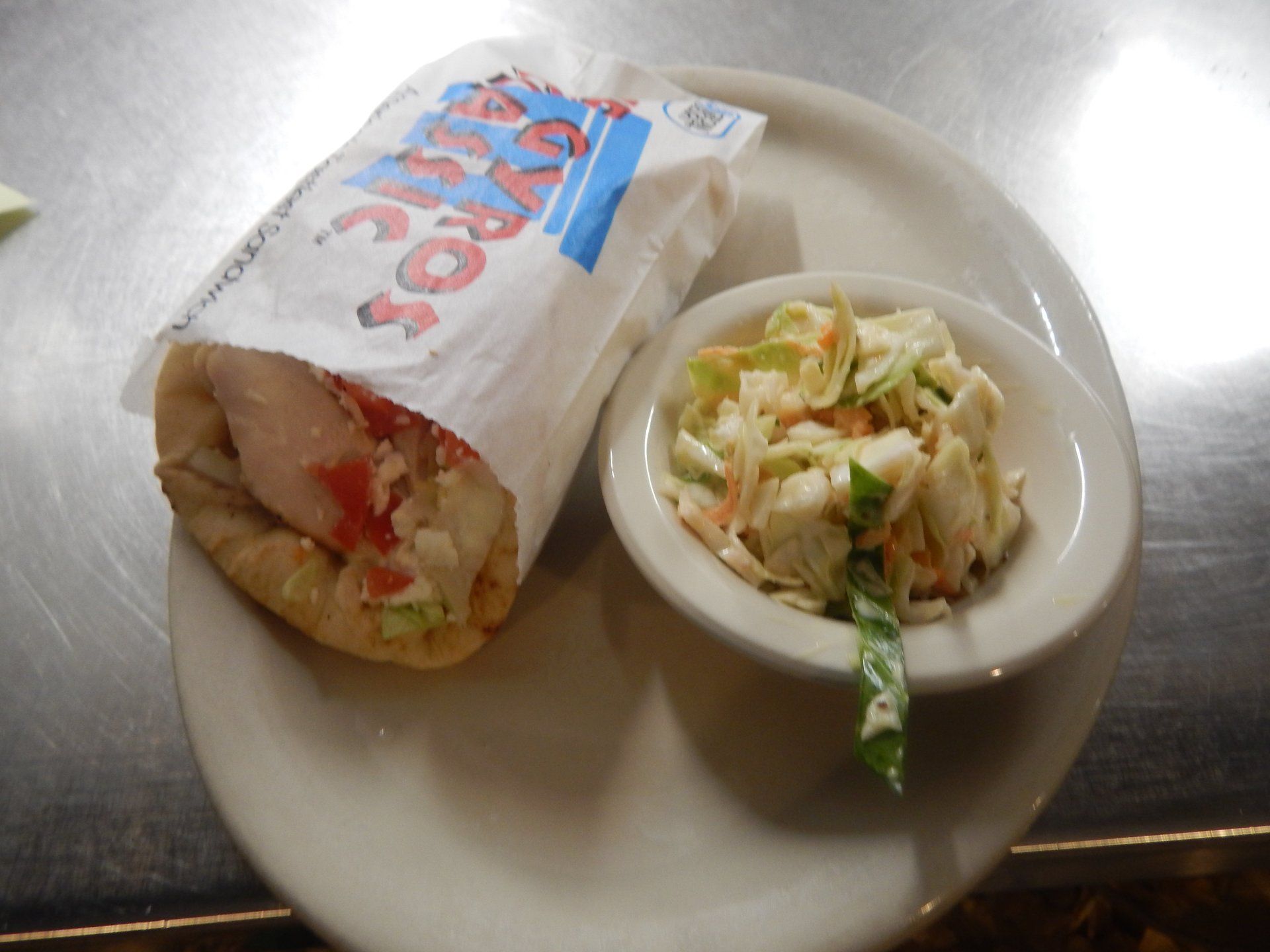 A plate with a gyro and coleslaw on it
