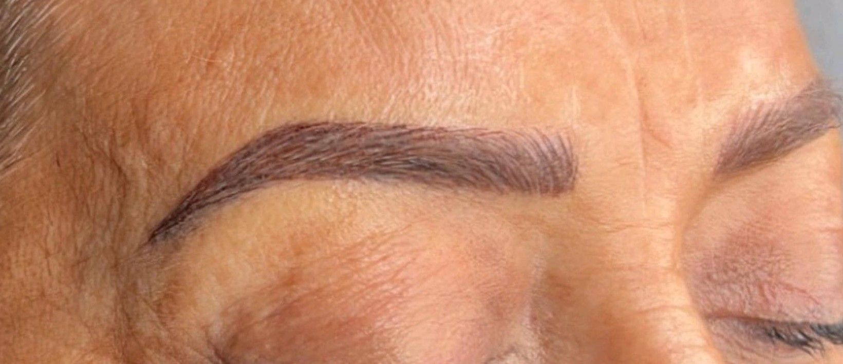 A close up of a woman 's eyebrows with her eyes closed.