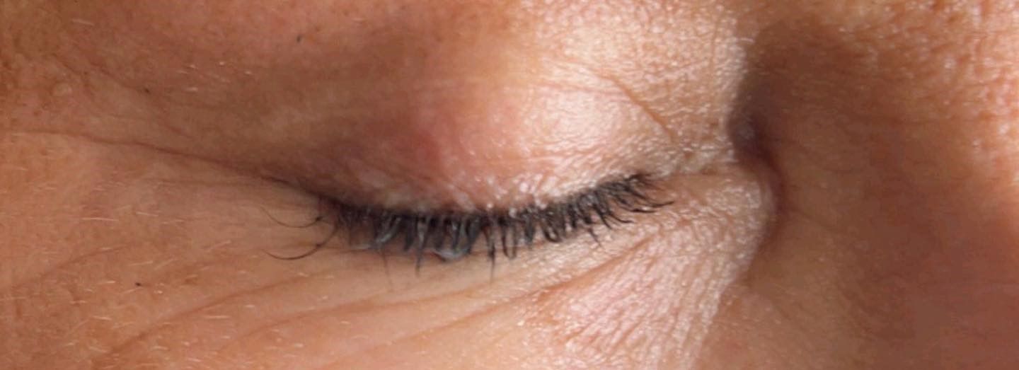 A close up of a woman 's eye with long eyelashes.