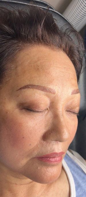 A woman is getting her eyelashes done at a beauty salon.