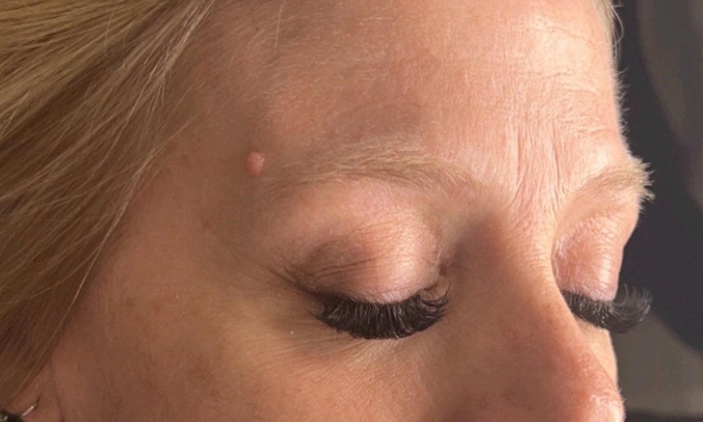 A close up of a woman 's face with long eyelashes.