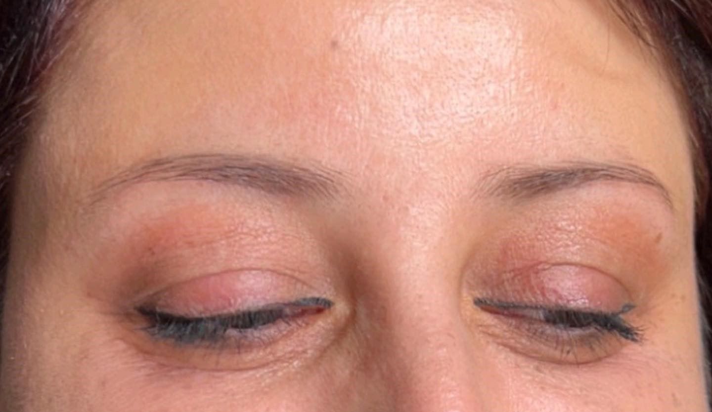 A close up of a woman 's face with her eyes closed.