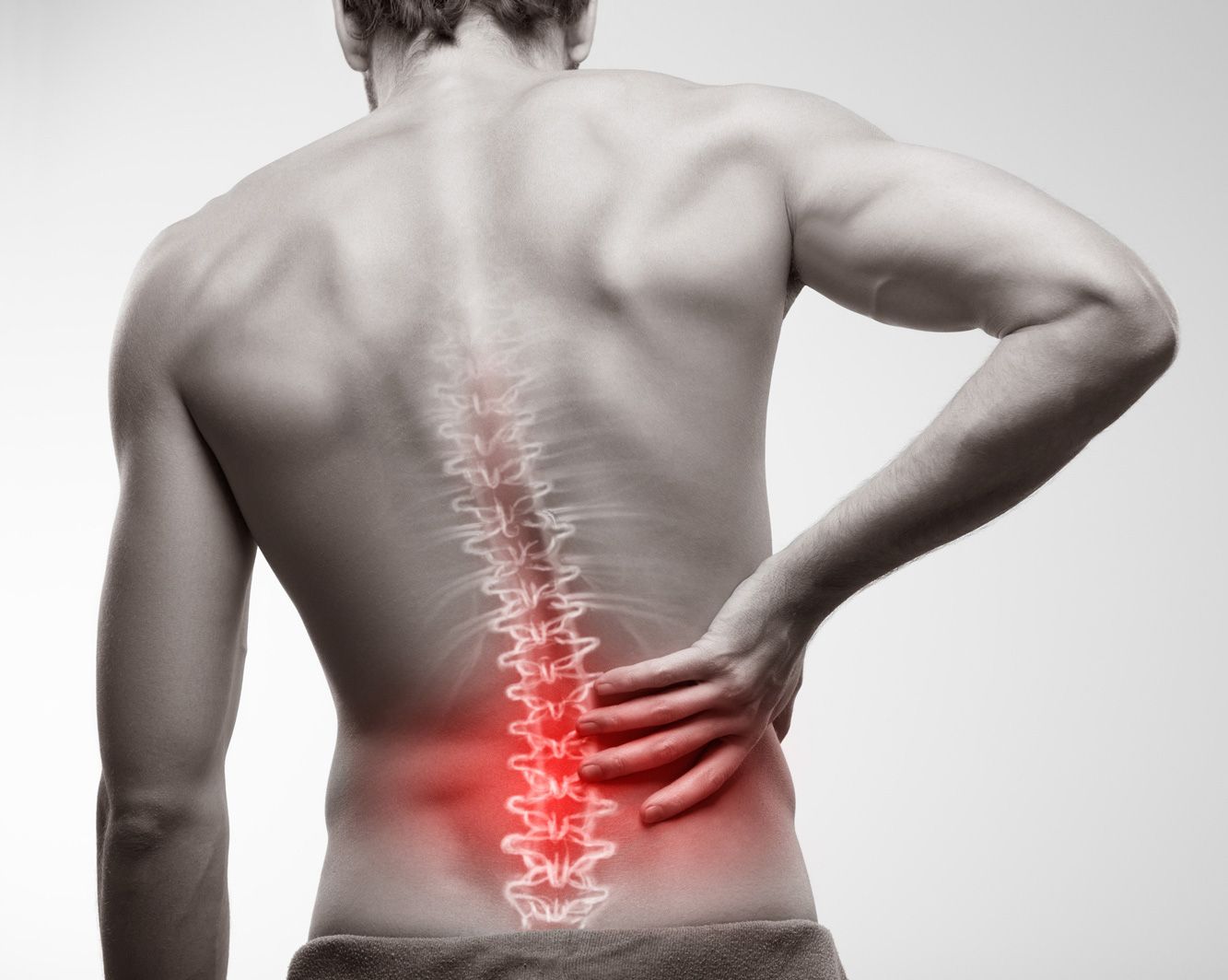 A man is holding his back in pain because of a backache