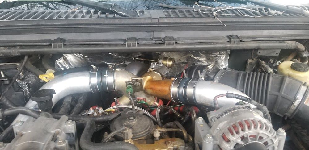 Engine components, with silver pipes and a brown connector.