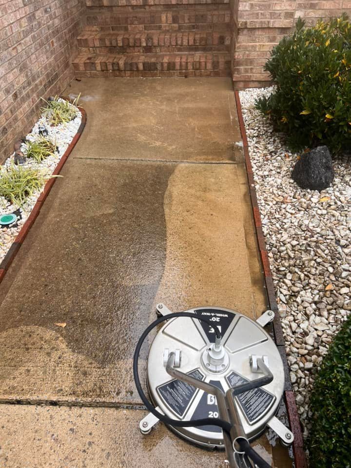 Sidewalk being cleaned with a pressure washer. One half is clean, the other is dirty.