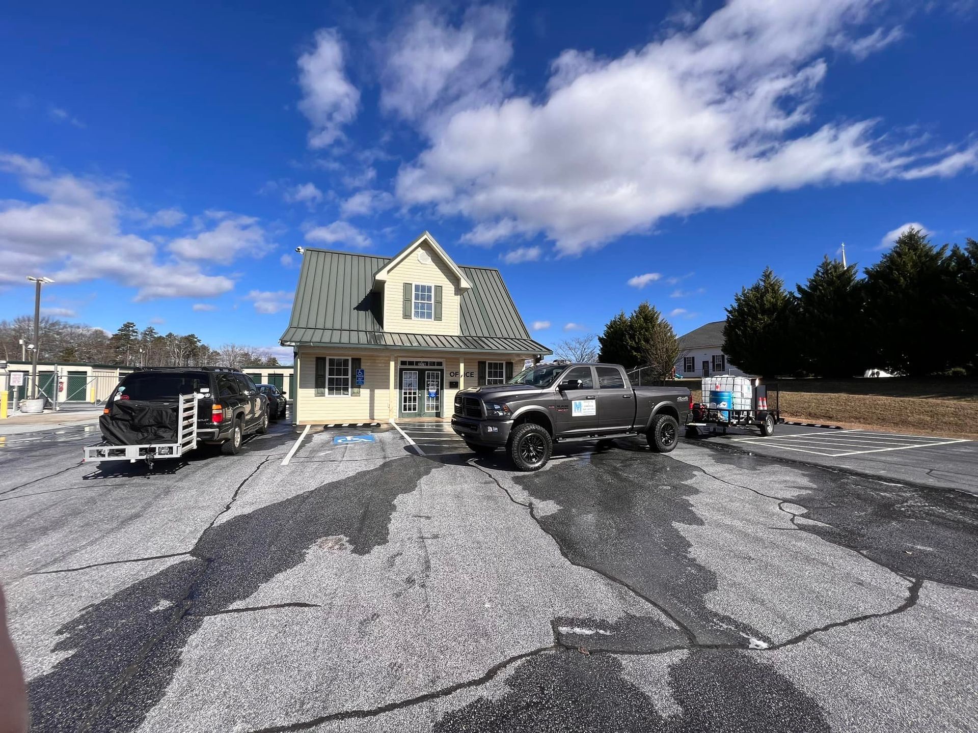 Vehicles parked in front of a small building under a cloudy sky.