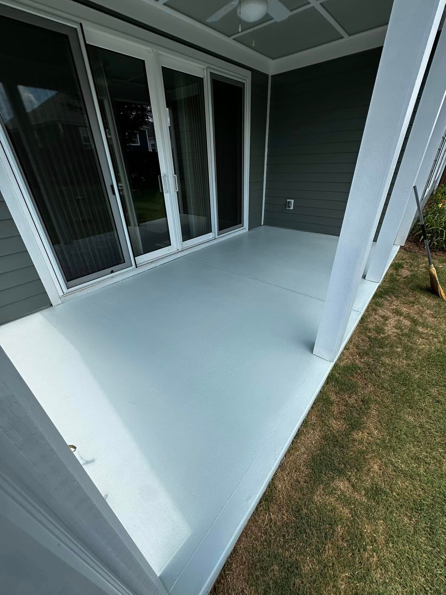 Gray painted patio with sliding glass doors, white trim, and a support beam. Grass is visible.