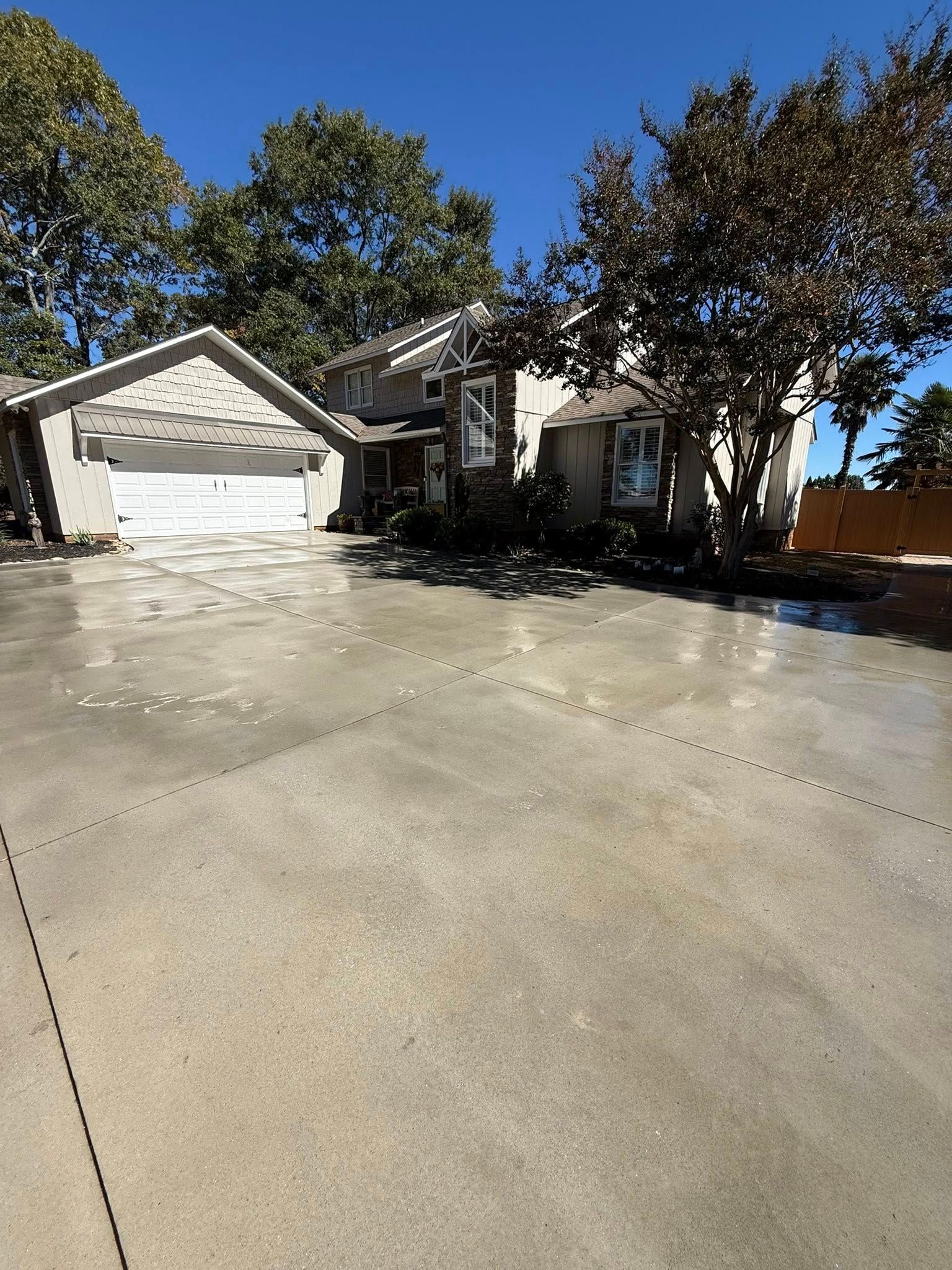 Concrete patio with a raised garden bed along a white siding house.
