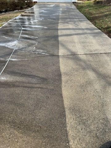Driveway, half cleaned with a pressure washer, showing the difference in cleanliness.