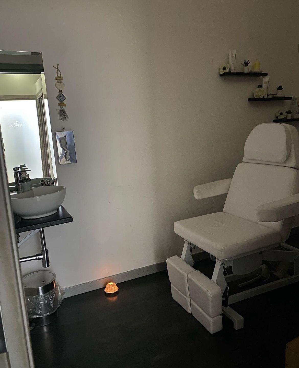 Una sedia bianca è posizionata in una stanza accanto a un lavandino.