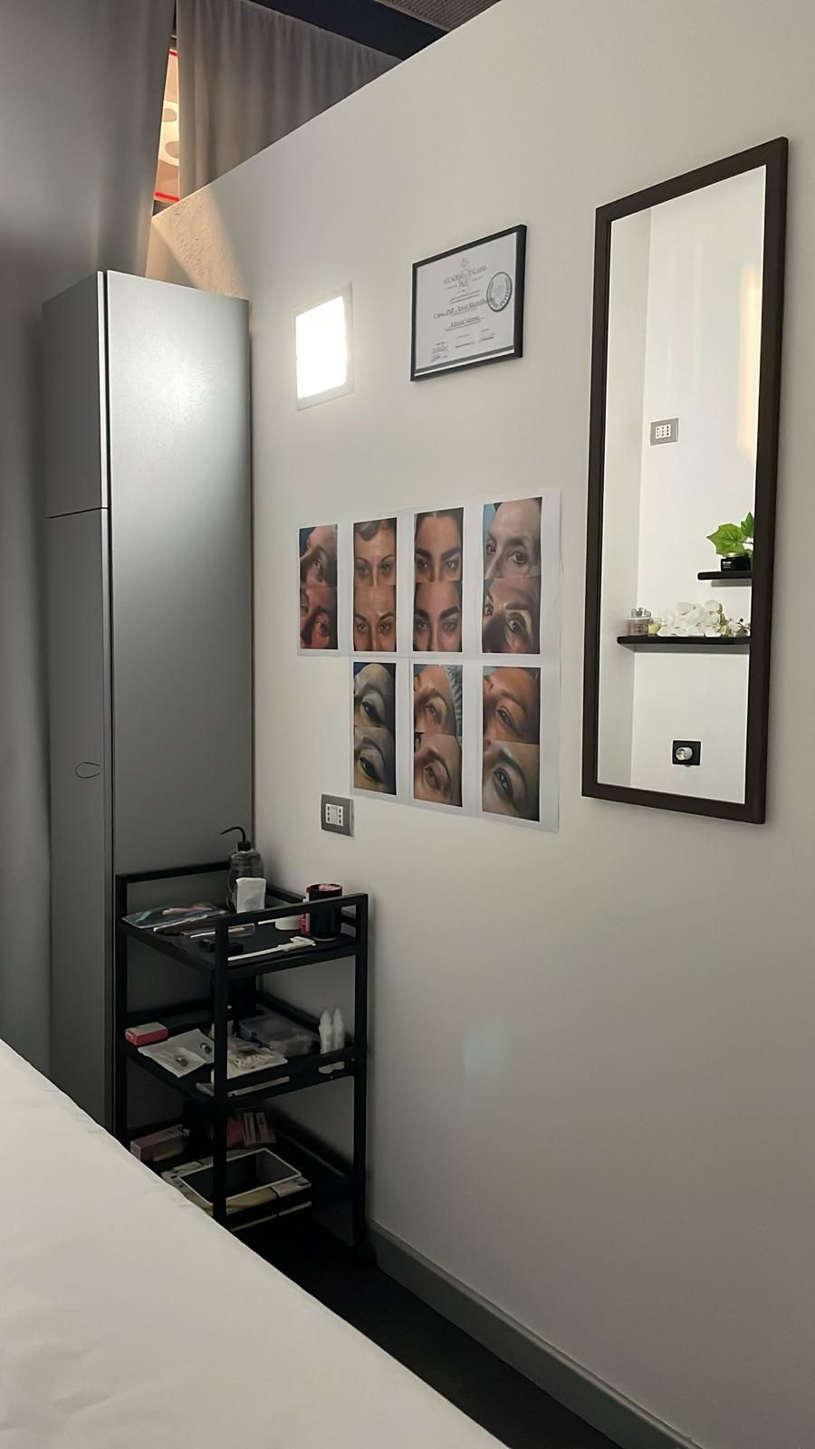 Una stanza con uno specchio e una mensola con dei quadri sul muro.