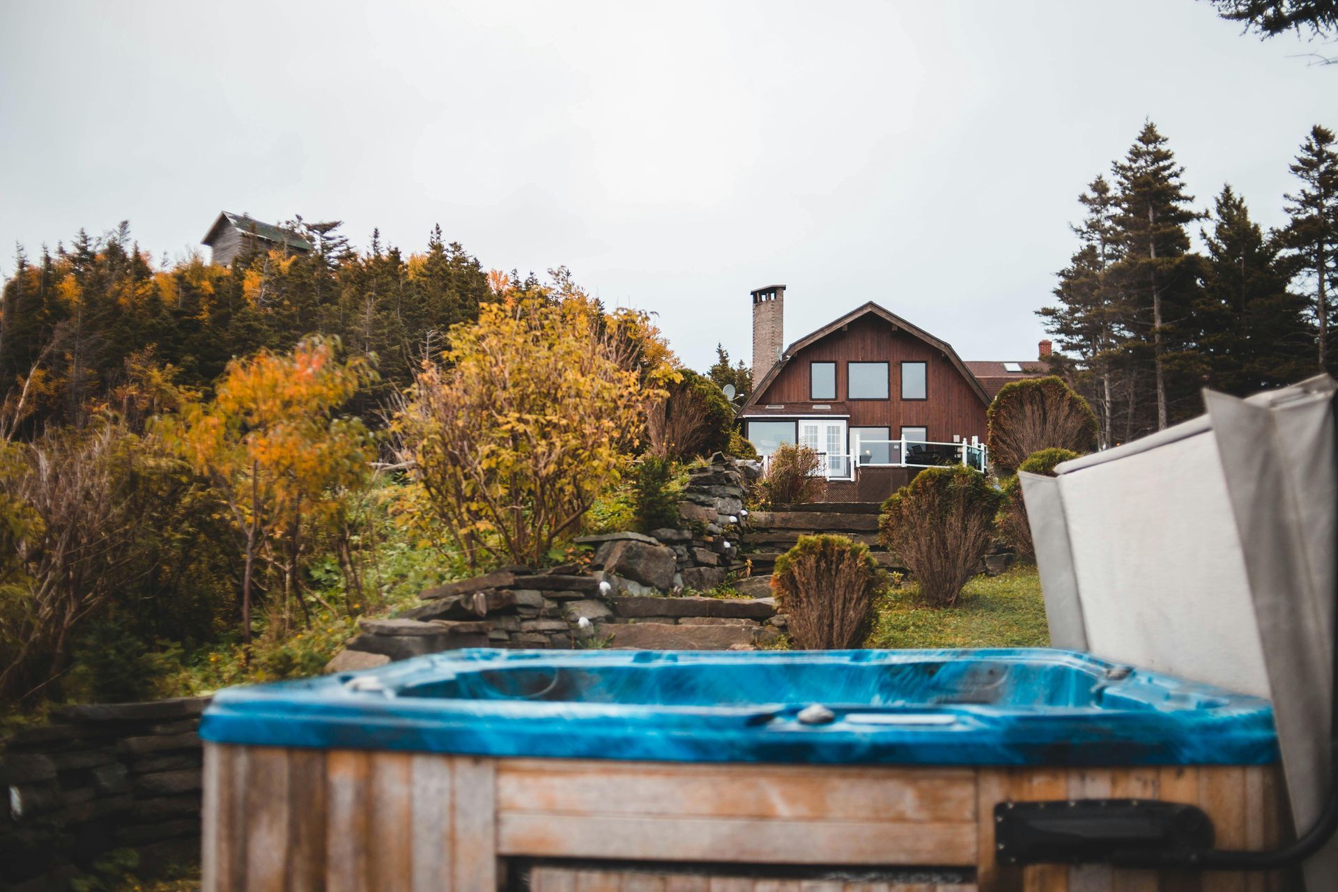 A blue hot tub is sitting in front of a house.