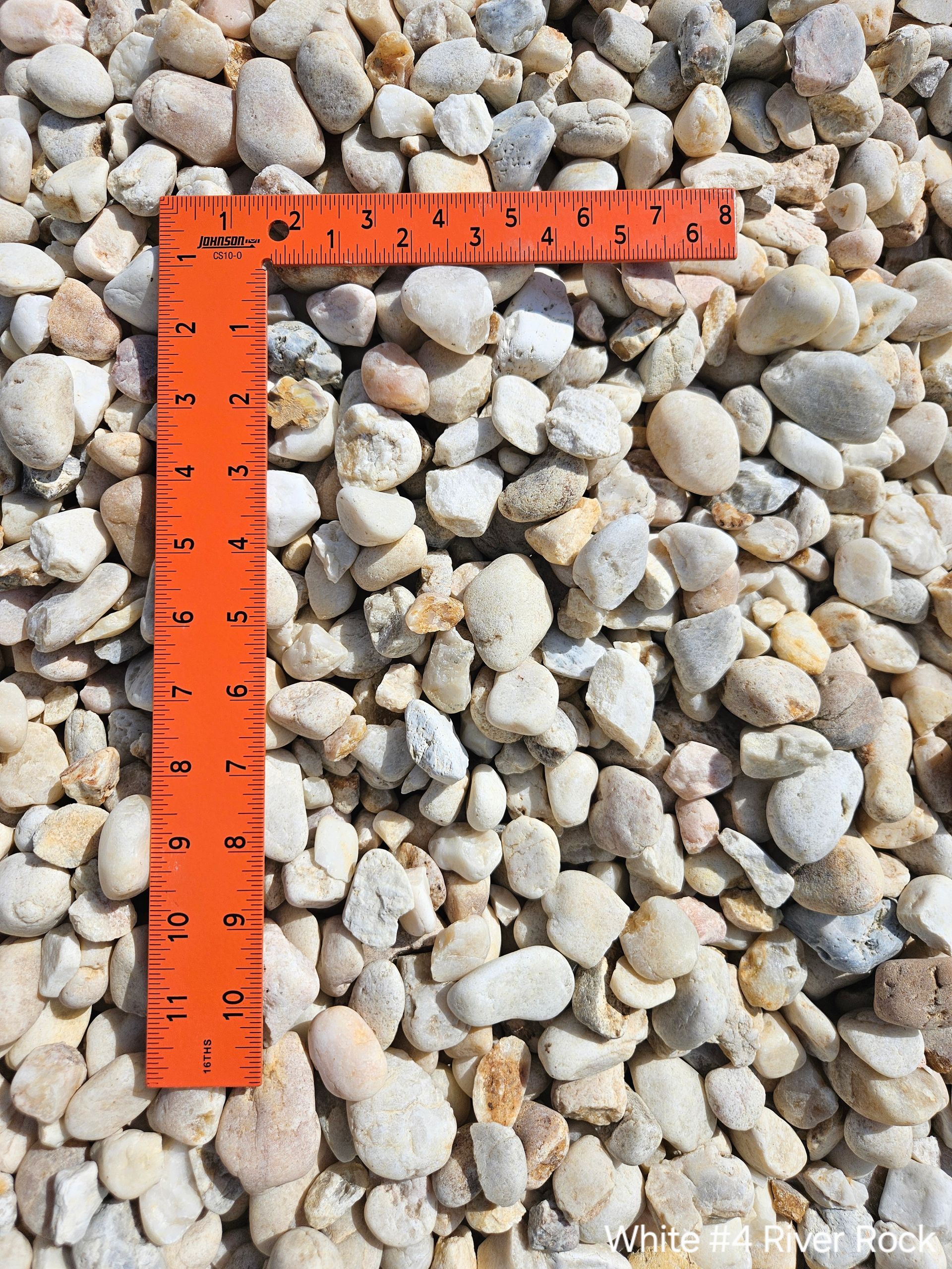 A close up of a gravel driveway next to a lawn.