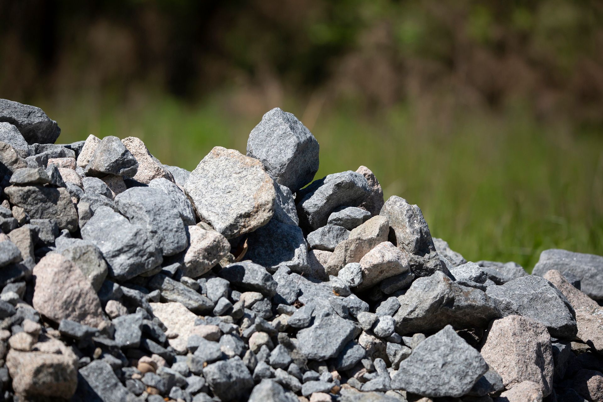 A pile of rocks is sitting on top of a grassy field.