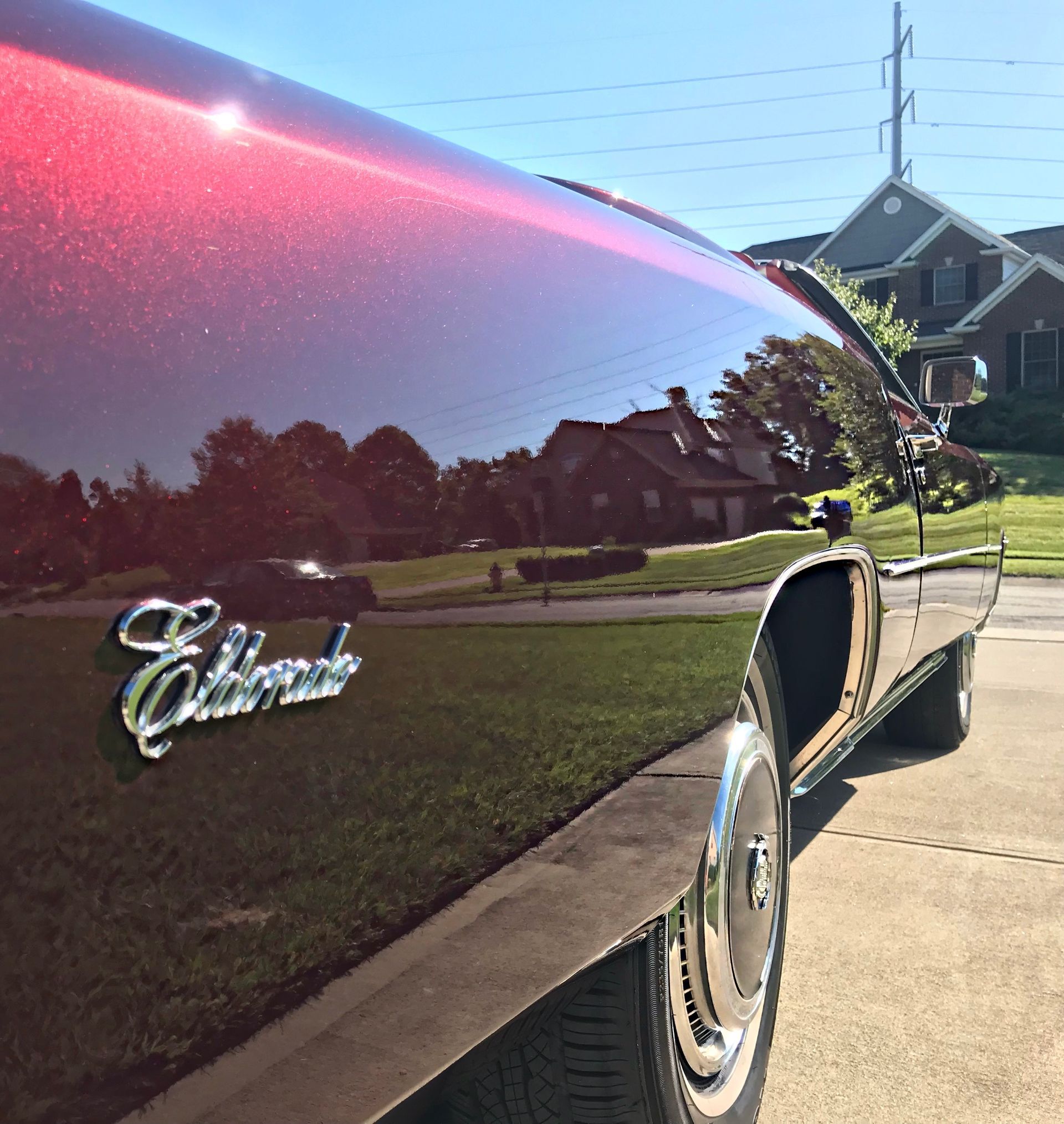 A man is polishing the side mirror of a car.