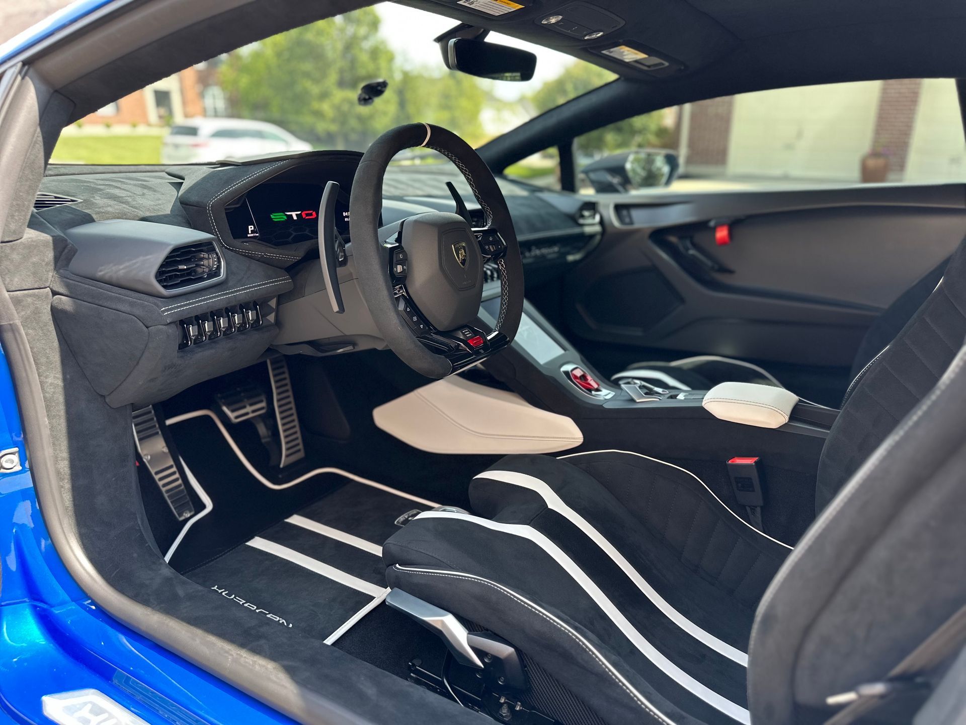 The interior of a blue sports car with black and white seats