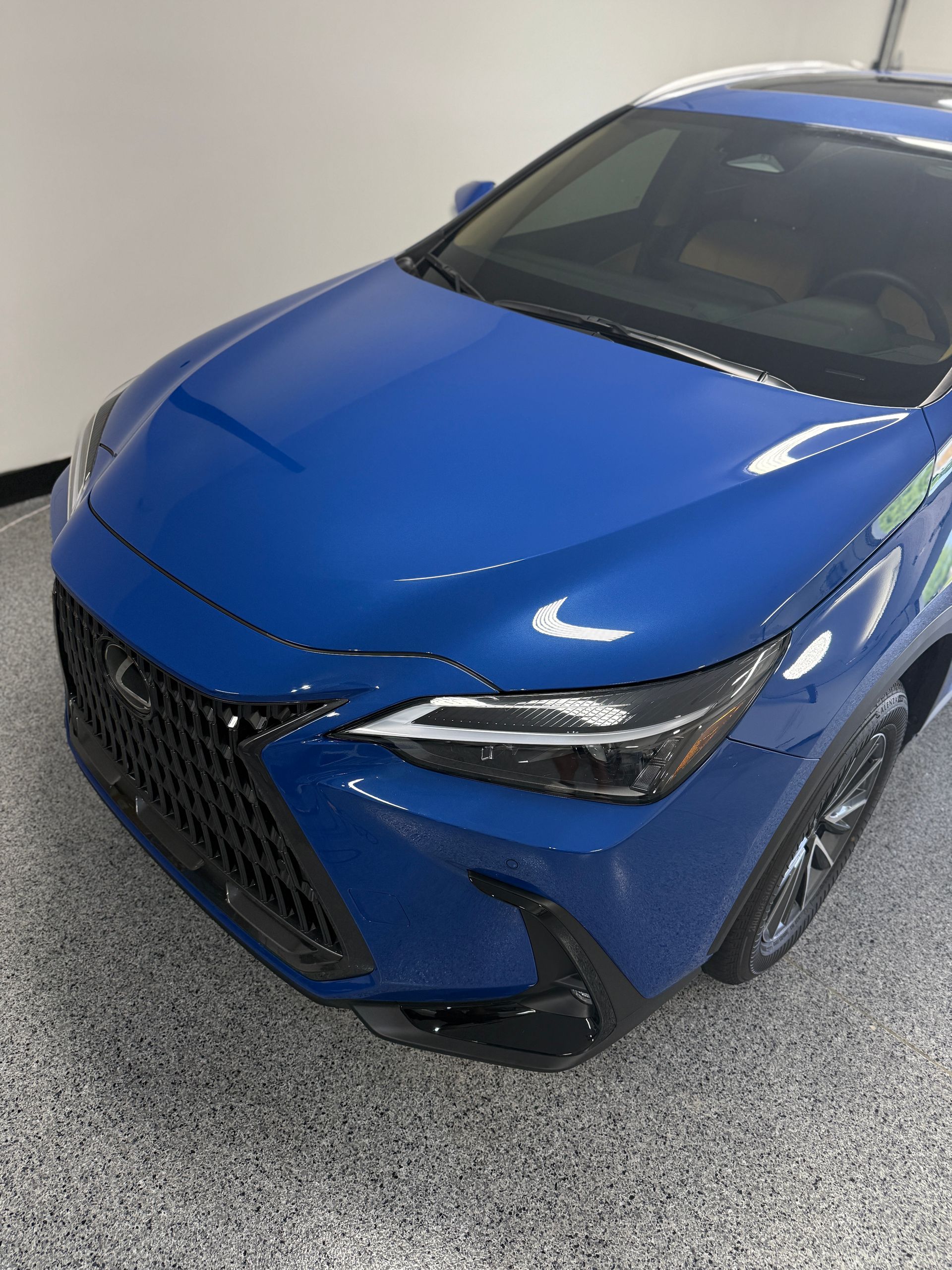 A blue car is parked in a garage.