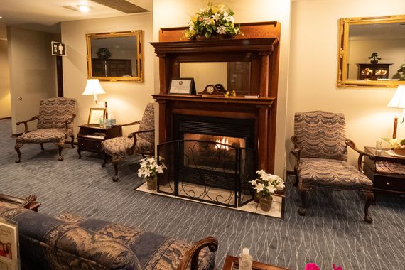 a wooden walkway leading to a gazebo overlooking a body of water at sunset .