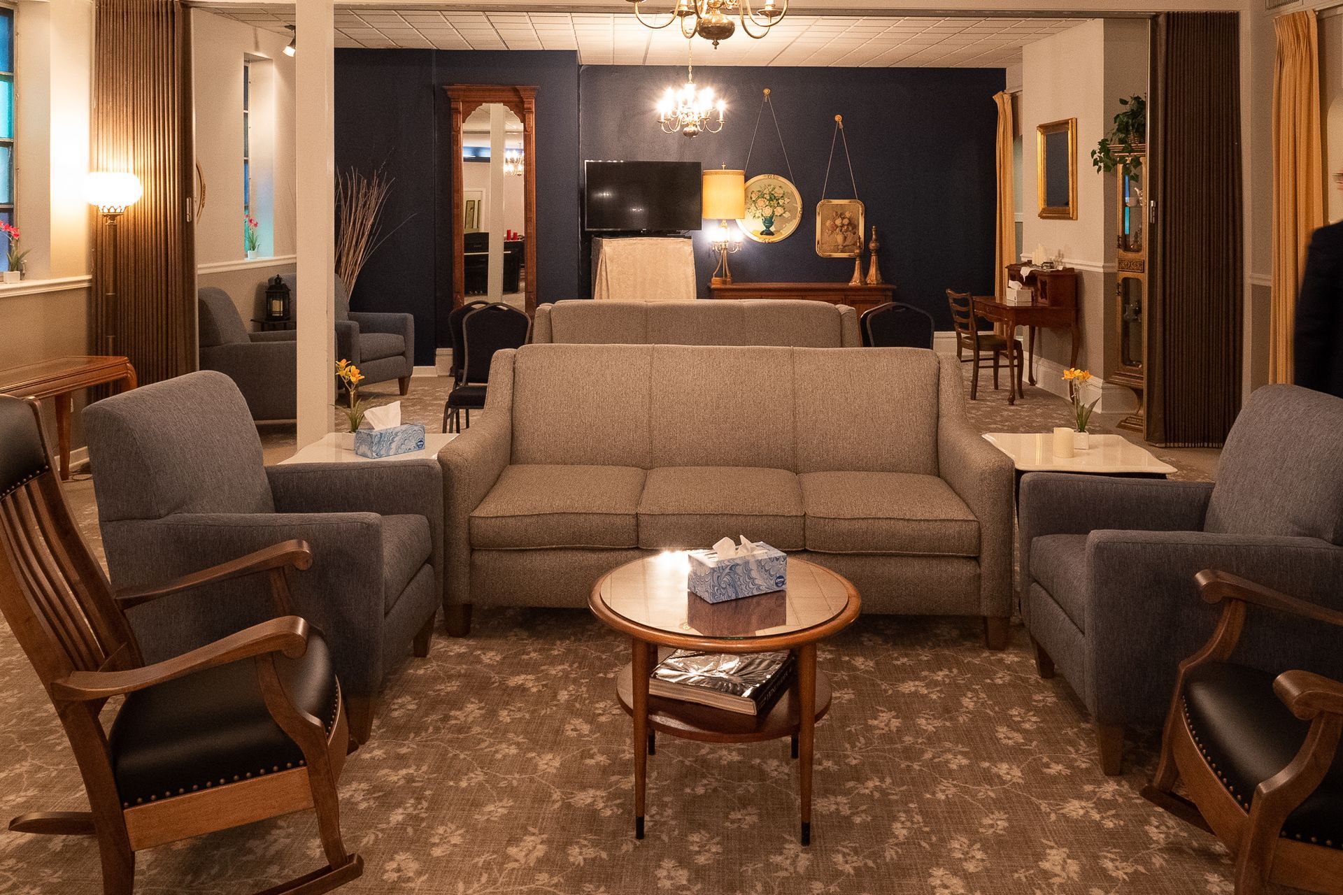 a wooden walkway leading to a gazebo overlooking a body of water at sunset .