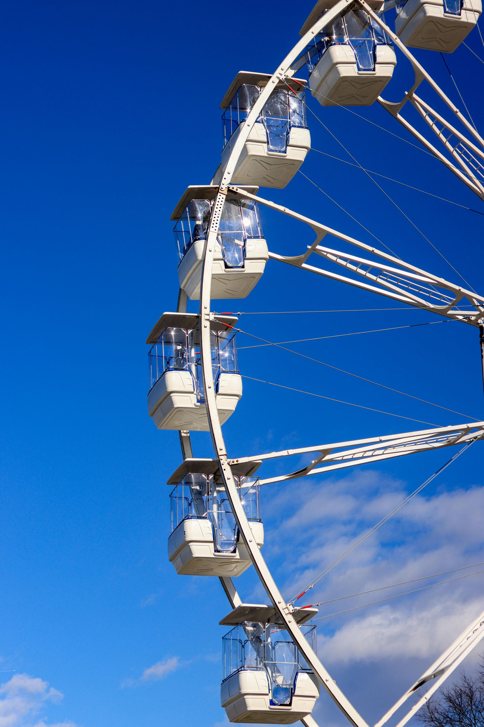 A ferris wheel against a blue sky with clouds