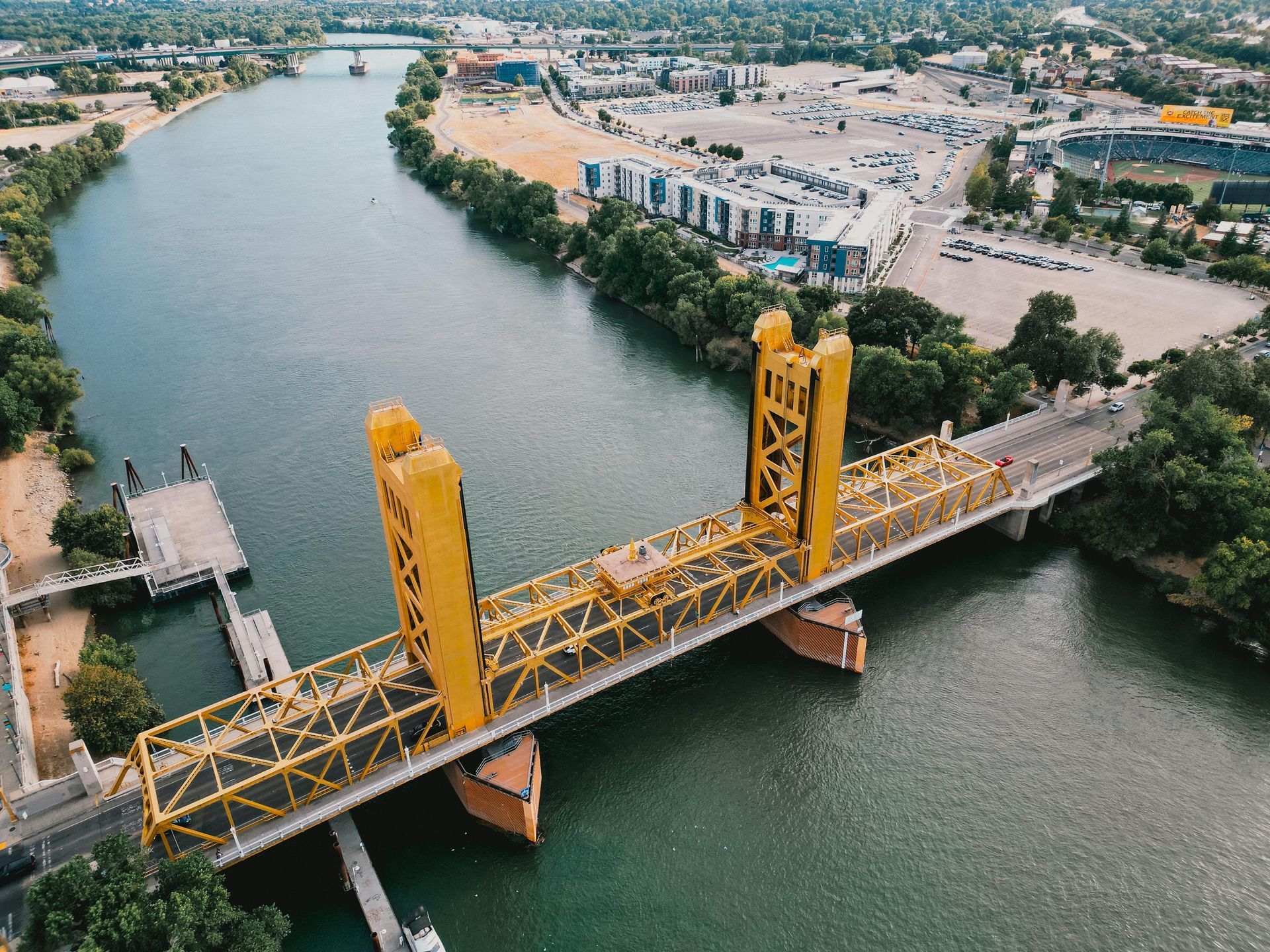 An aerial view of a yellow bridge over a river.