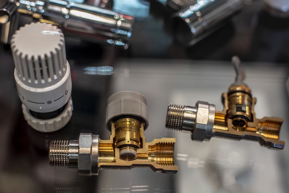 A Close Up of Two Radiator Valves on a Table — Ryno's Plumbing Group in Wauchope, NSW