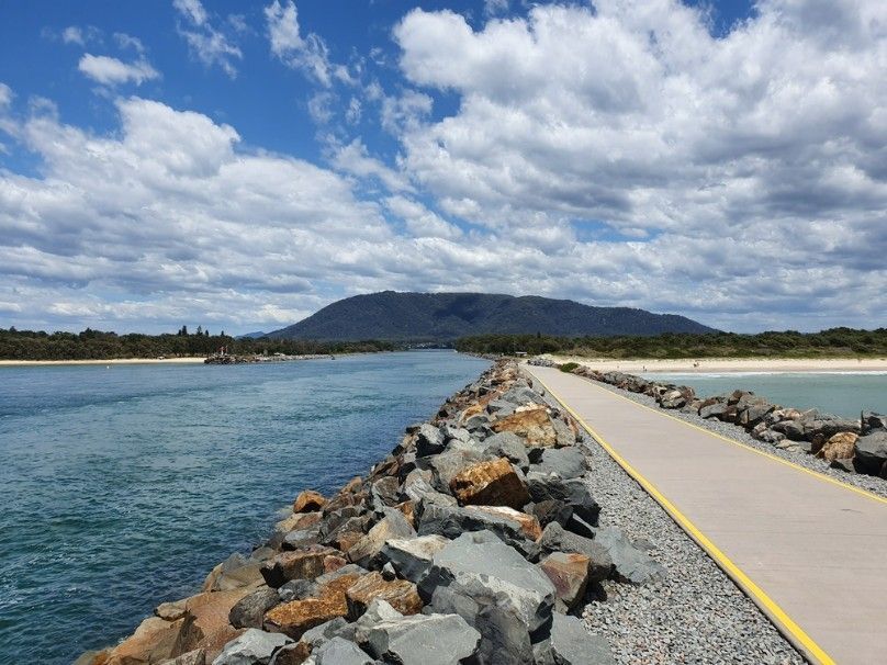 A Road Going Over a Body of Water With a Mountain in the Background — Ryno's Plumbing Group in Laurieton, NSW