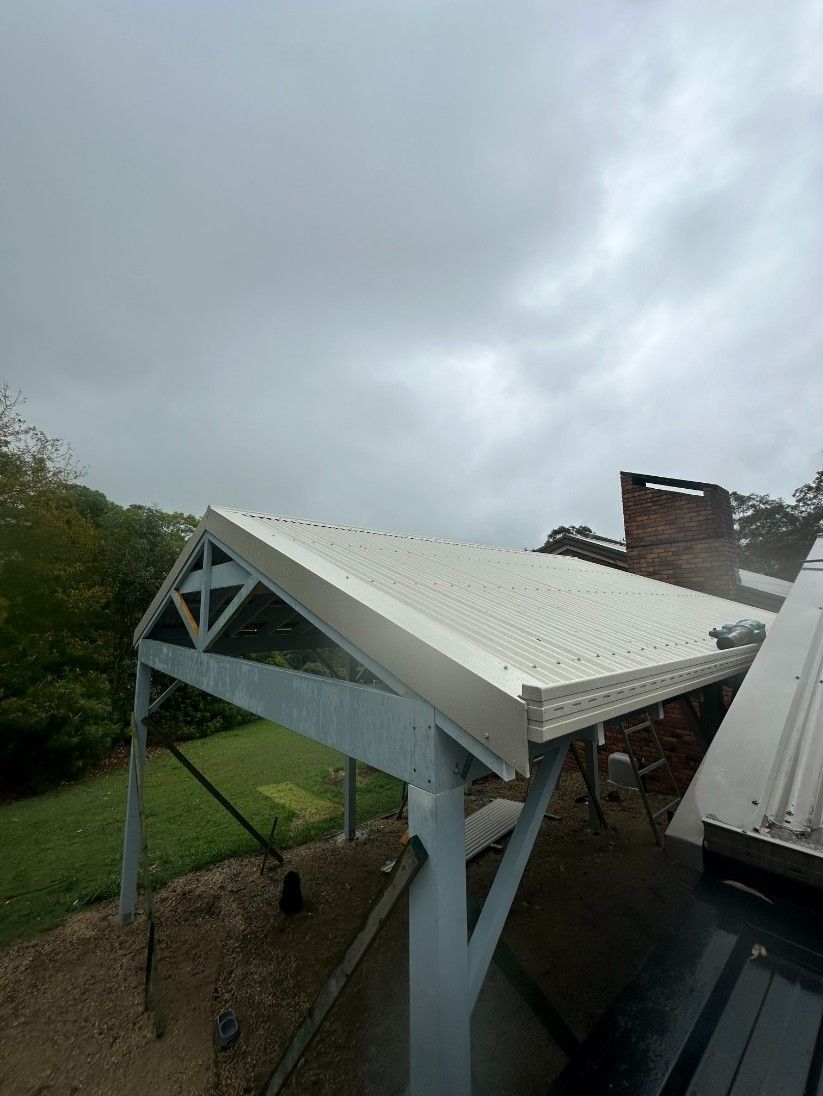 A Roof With a White Roof and a Gray Sky in the Background — Ryno's Plumbing Group in Lakewood, NSW