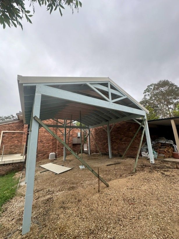A Carport is Being Built in the Backyard of a House — Ryno's Plumbing Group in Lakewood, NSW