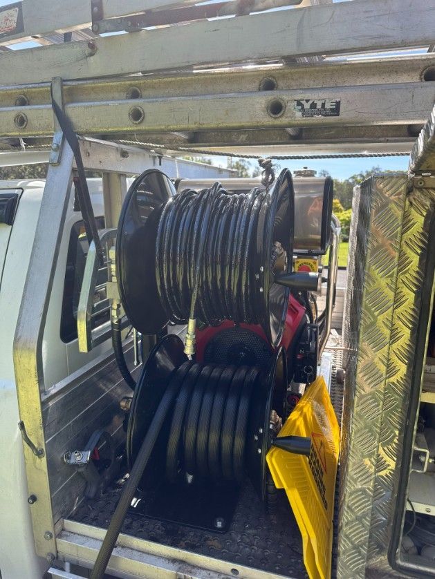 A Hose Reel is Attached to the Back of a Truck — Ryno's Plumbing Group in Lakewood, NSW