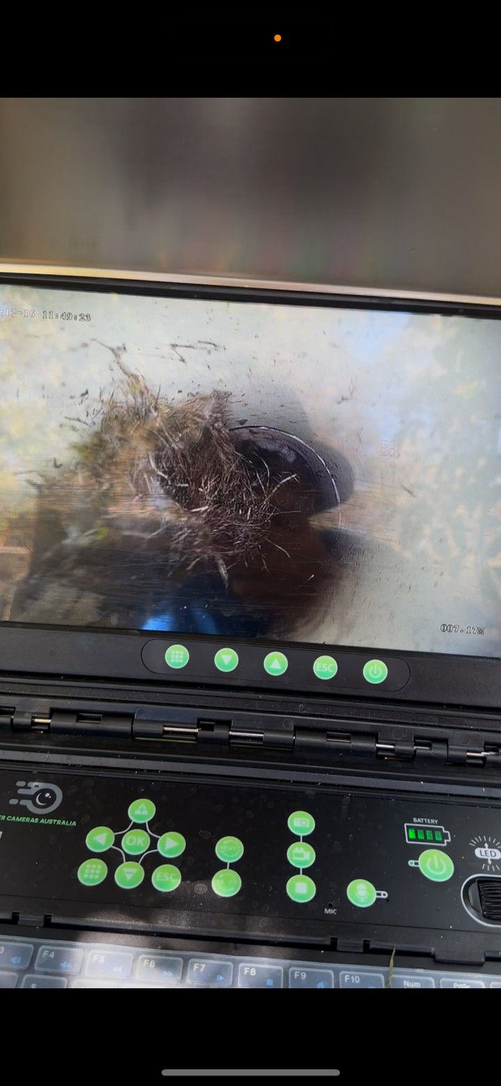 A Laptop With a Picture of a Hole in the Wall on the Screen — Ryno's Plumbing Group in Lakewood, NSW
