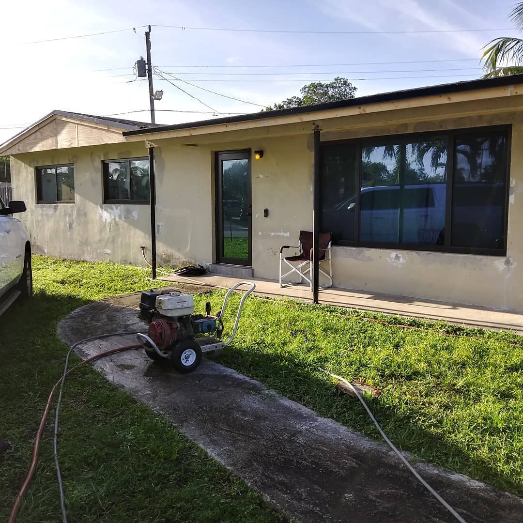 A house with a lawn mower parked in front of it.