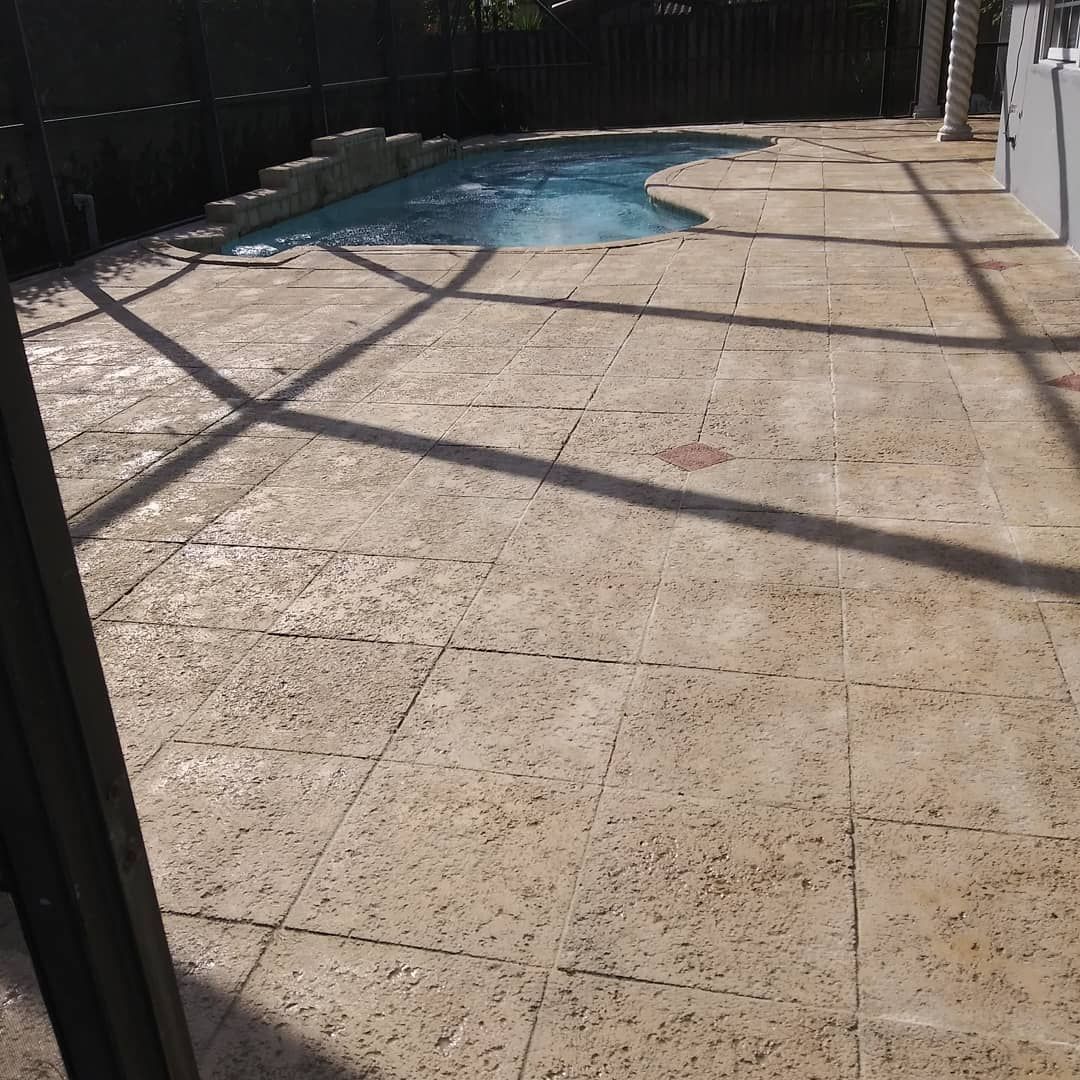 A patio with a swimming pool in the background