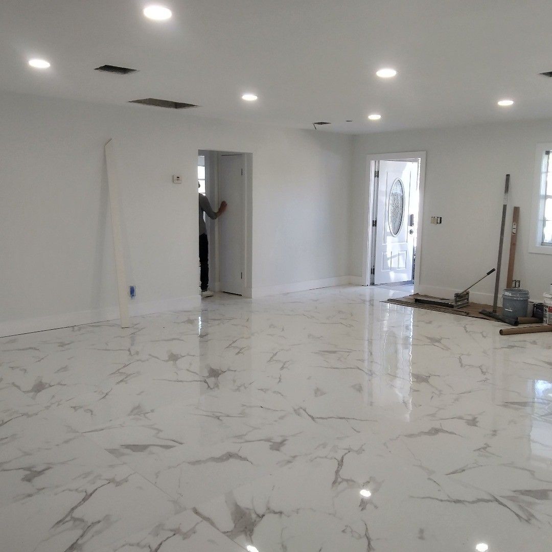 A large empty room with a marble floor and white walls.