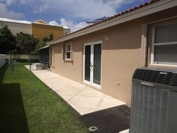 The back of a house with a patio and an air conditioner