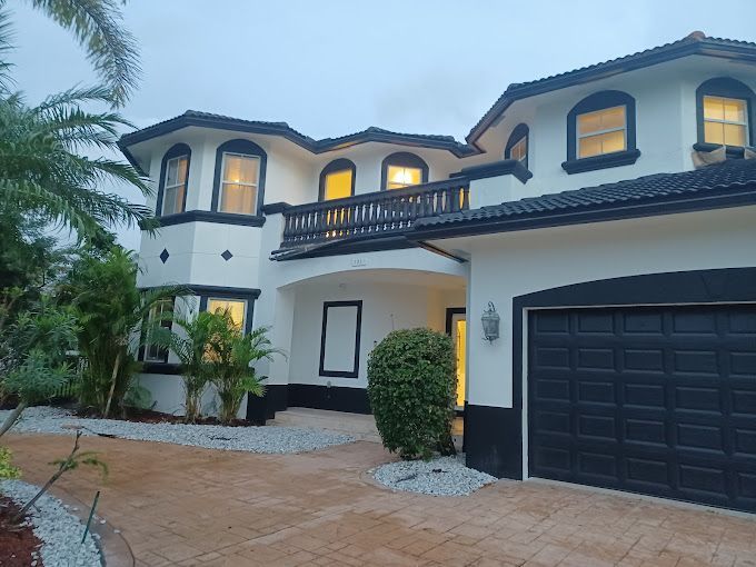 A large white and black house with a black garage door